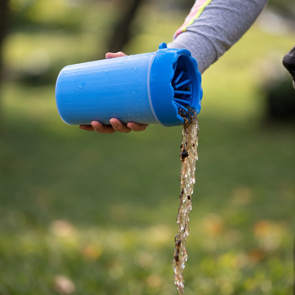 Pouring the dirty water out of the PawWash cup after cleaning